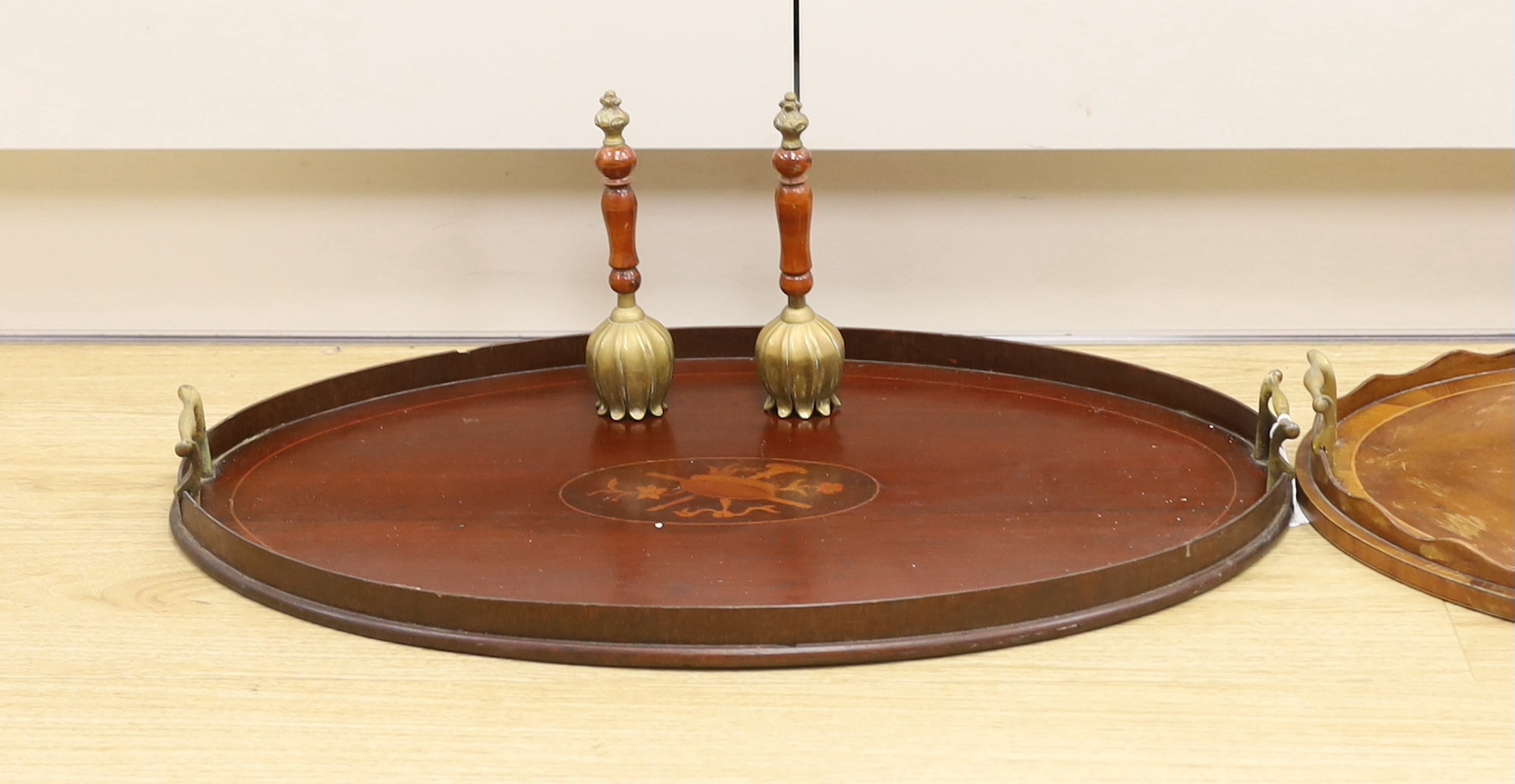 Two oval inlaid Edwardian trays with handles, larger 62cm wide, and two hand bells